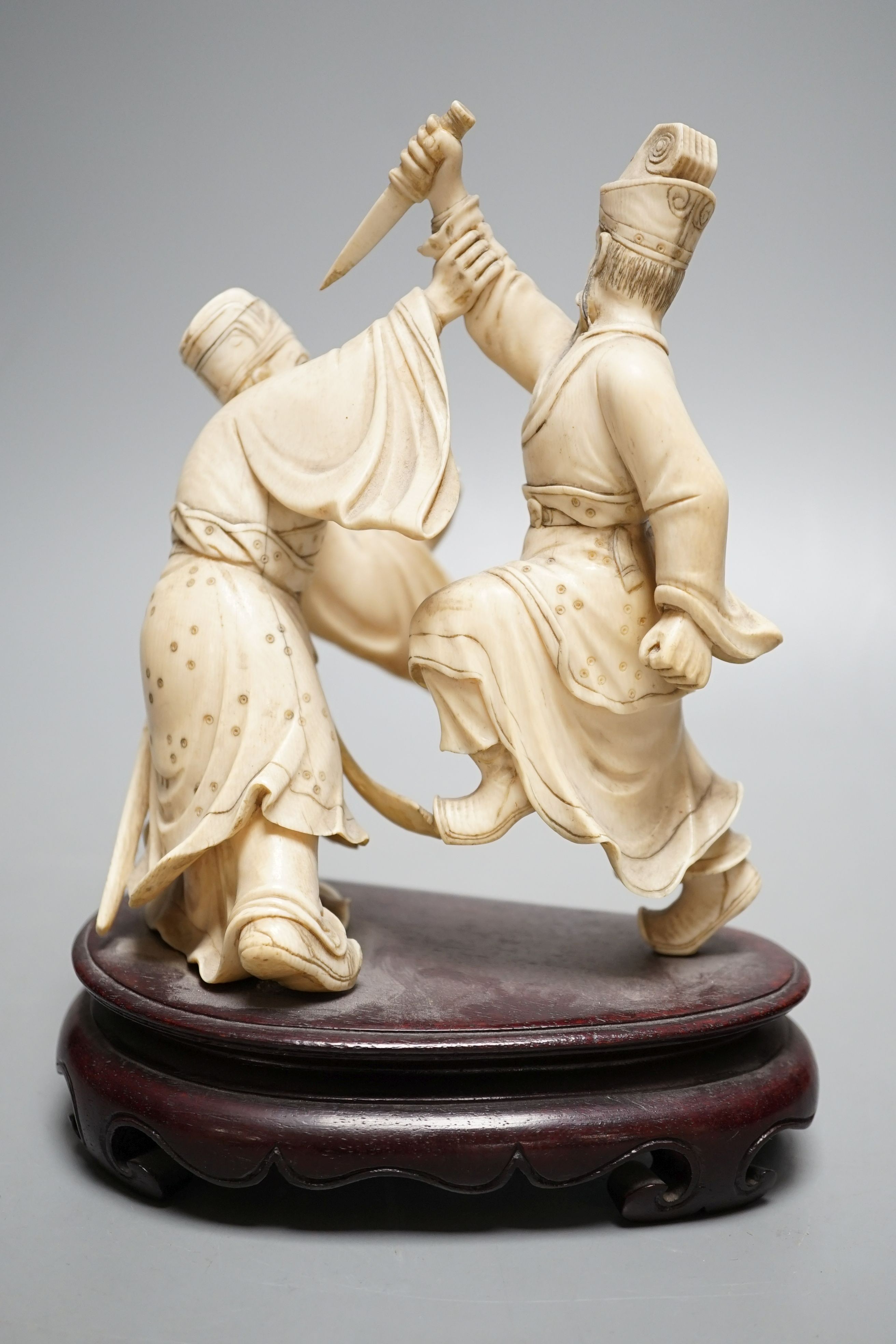 An early 20th century Chinese ivory group of two fighting officials - 21cm tall